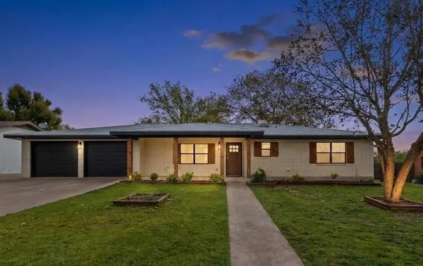 a front view of a house with a garden and yard