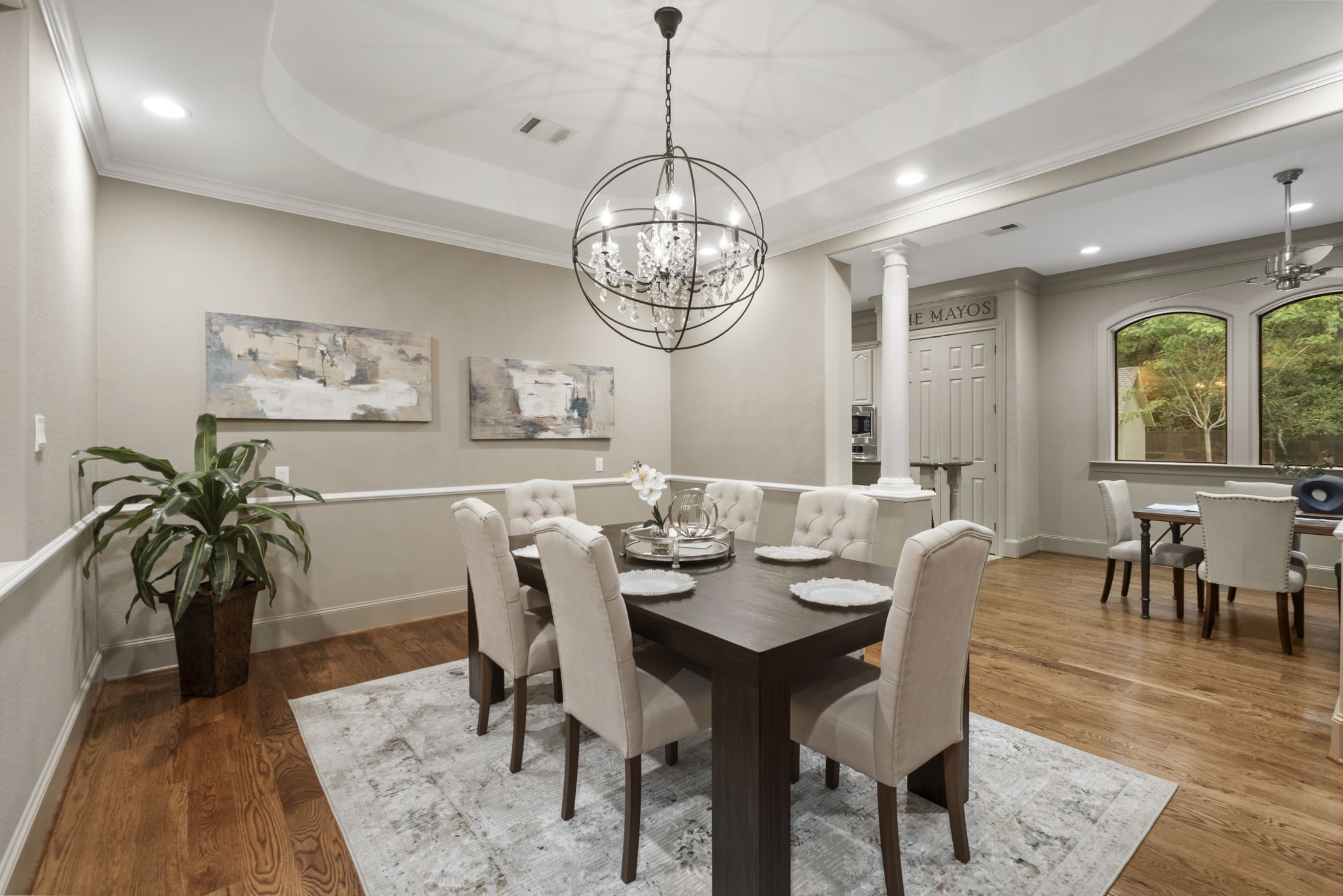 20010 Timber Ridge Drive Magnolia, TX 77355 - Photo 11 of 50 Elegant formal dining room featuring a tray ceiling, statement chandelier, and rich hardwood floors, offering a refined setting for gatherings and special occasions.