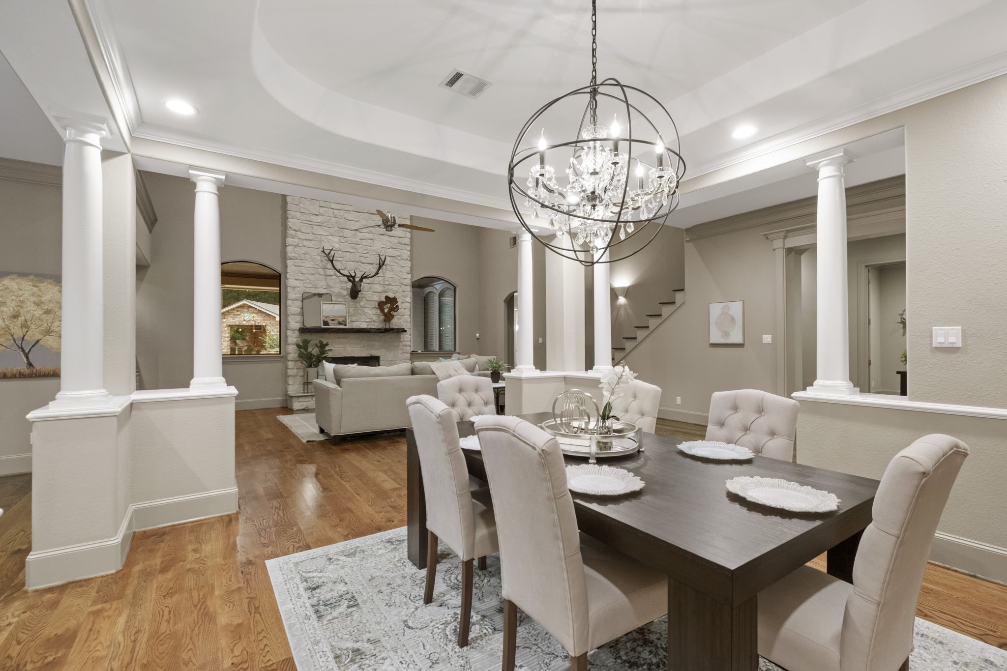 20010 Timber Ridge Drive Magnolia, TX 77355 - Photo 12 of 50 Spacious formal dining room framed by classic architectural columns and open sightlines into the main living area, creating a seamless flow for entertaining while showcasing the home’s timeless design and impressive scale.