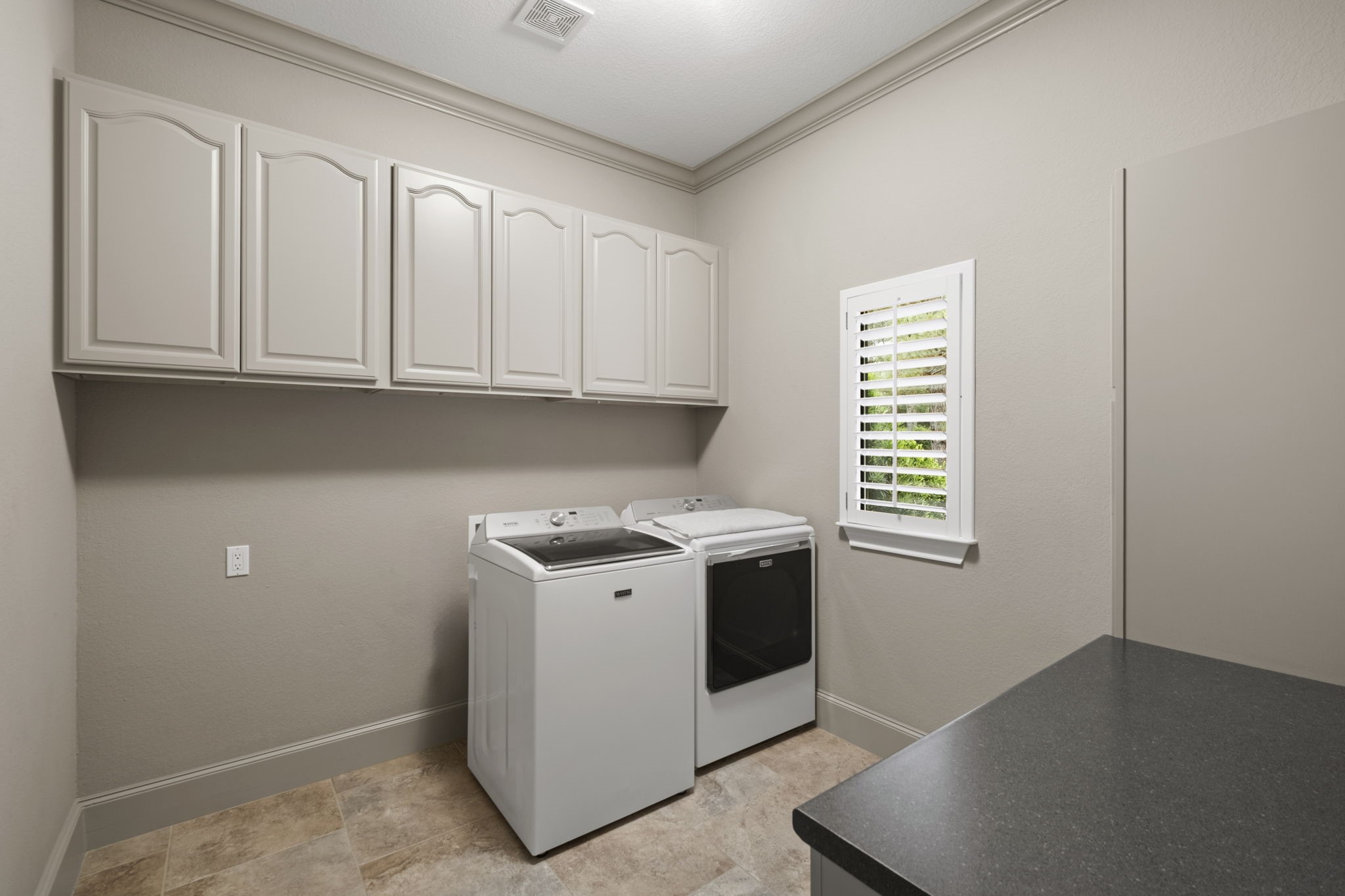 20010 Timber Ridge Drive Magnolia, TX 77355 - Photo 18 of 50 This bright, spacious laundry room provides a washer and dryer connections, overhead and side cabinets for storage, a window with shutters, and a countertop for folding clothes. It is located right off the kitchen.