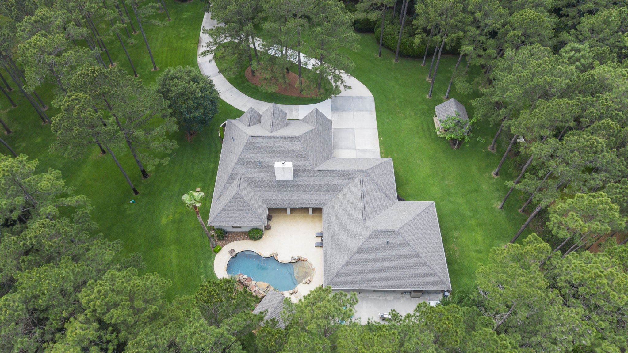 20010 Timber Ridge Drive Magnolia, TX 77355 - Photo 2 of 50 Nestled in the serene embrace of lush greenery, this exquisite home on features a stunning pool and expansive outdoor space, offering a perfect blend of luxury and tranquility. Your dream home awaits!