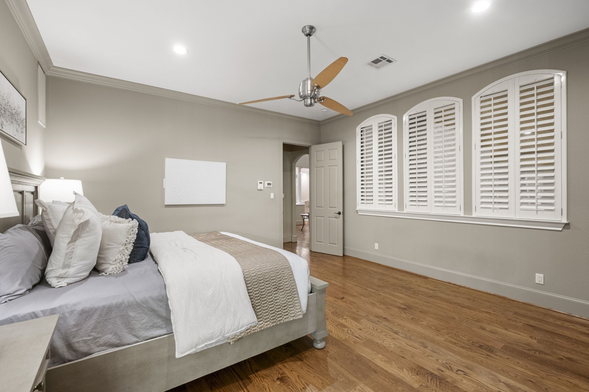 20010 Timber Ridge Drive Magnolia, TX 77355 - Photo 20 of 50 Another view of the primary bedroom showcases the lovely crown molding and large, arched windows with plantation shutters which allow natural light to flood across the rich wood floors.