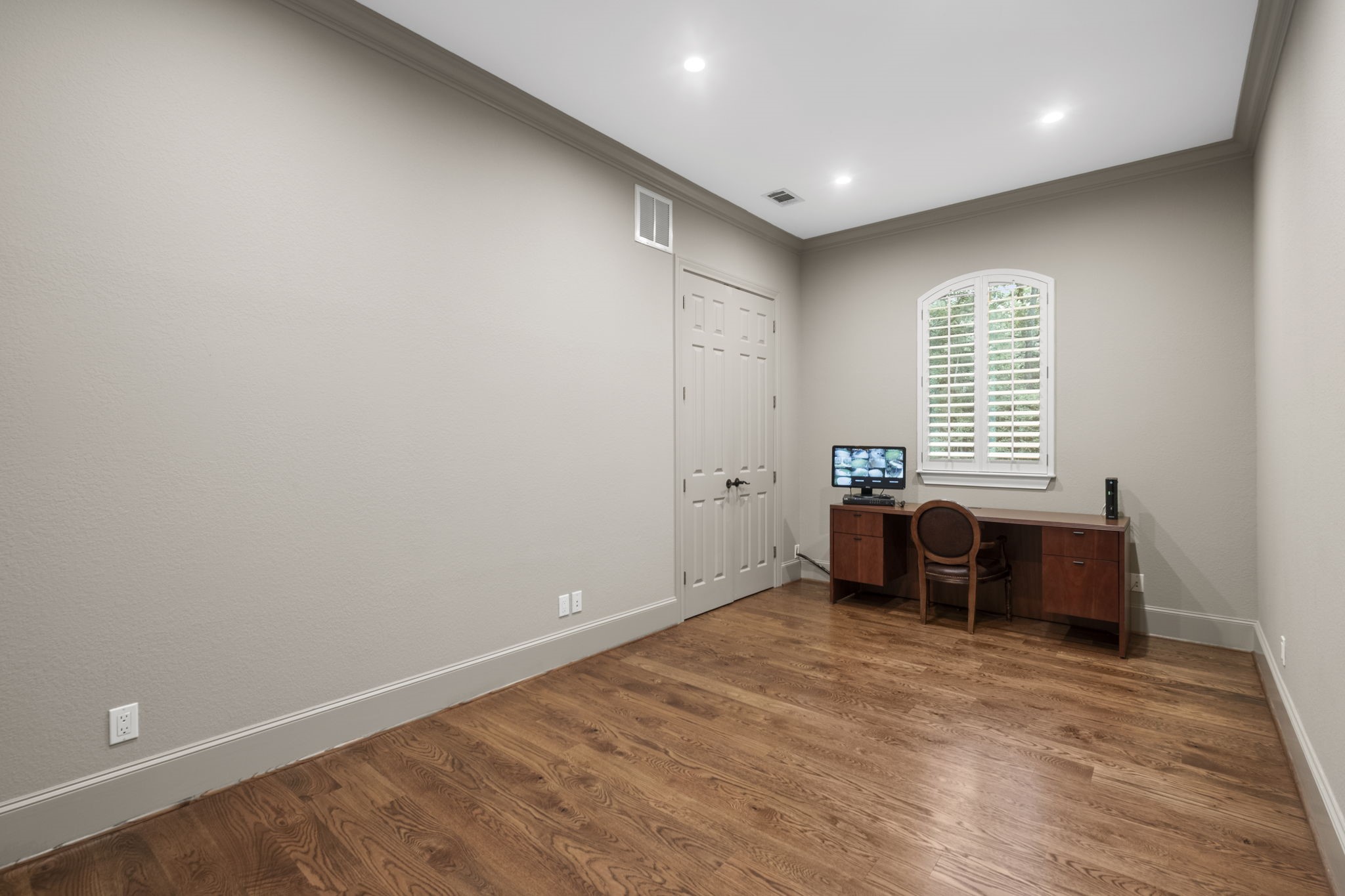 20010 Timber Ridge Drive Magnolia, TX 77355 - Photo 24 of 50 This first-floor secondary bedroom boasts hardwood floors, crown molding, and recessed lighting. It features a window with shutters, ample electrical outlets, and a closet with double doors for storage.