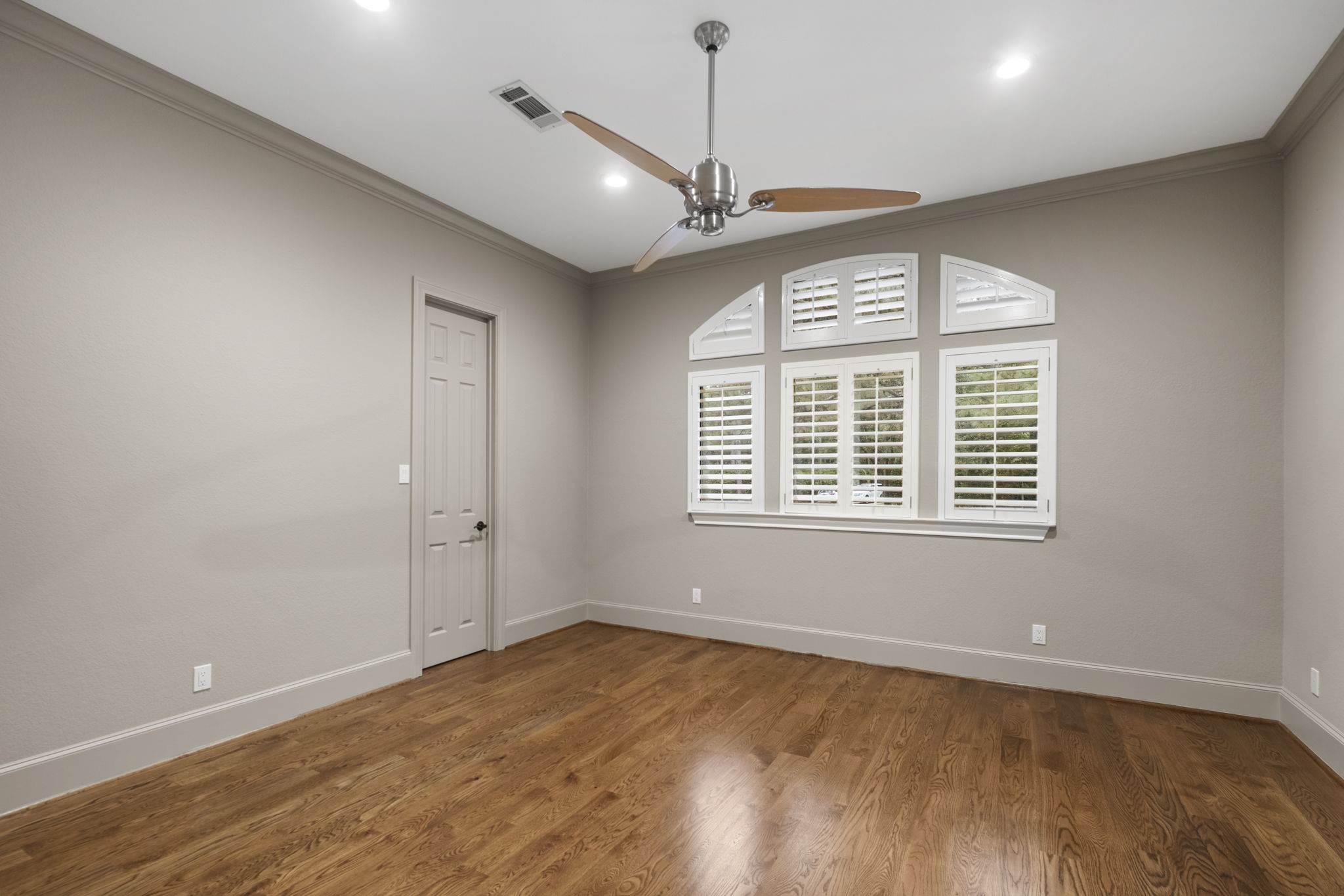 20010 Timber Ridge Drive Magnolia, TX 77355 - Photo 25 of 50 Another first-floor bedroom provides a welcoming space for relaxation. Boasting rich wood floors, recessed lighting, ceiling fan, and plantation shutters covering the windows, this bedroom will be a cozy retreat for family or guests.