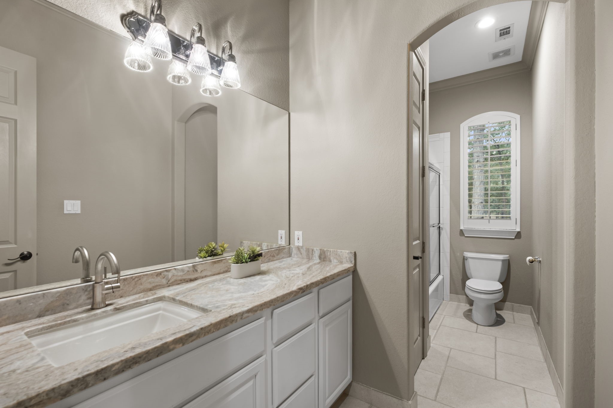 20010 Timber Ridge Drive Magnolia, TX 77355 - Photo 26 of 50 This well-appointed secondary bathroom combines practicality with comfort, featuring a convenient shower-tub combo and closet storage. A sleek vanity with ample counter space and cabinet storage provides everyday functionality, while the clean, inviting design makes it ideal for guests or family use.