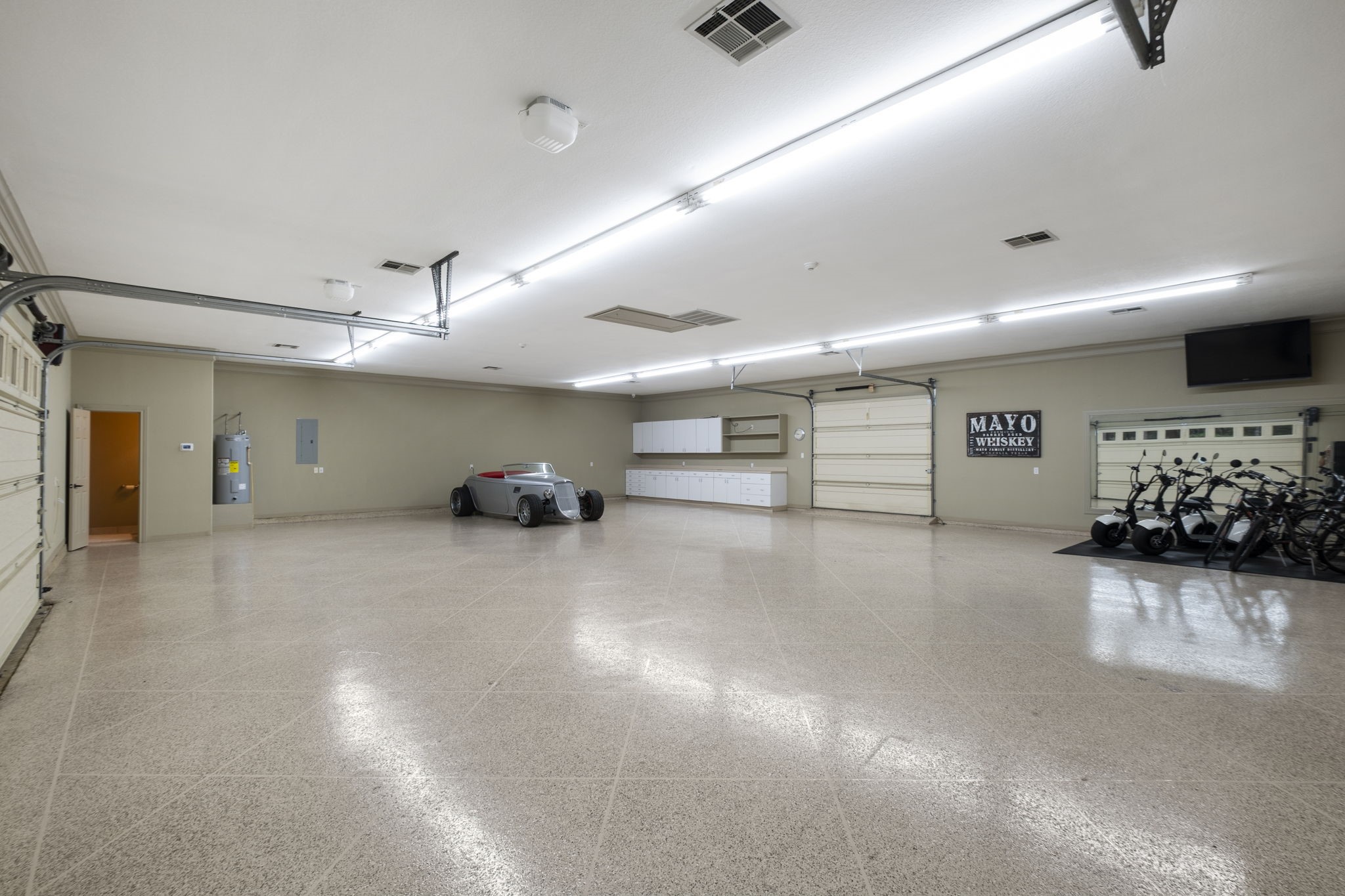 20010 Timber Ridge Drive Magnolia, TX 77355 - Photo 39 of 50 This spacious, well-lit 9-car garage features an epoxy floor, ample storage cabinets, several garage doors entrances, and multiple parking spaces ideal for car enthusiasts or as a versatile workspace! For added convenience, there is a half-bath located inside the garage. New AC was installed in 2026!