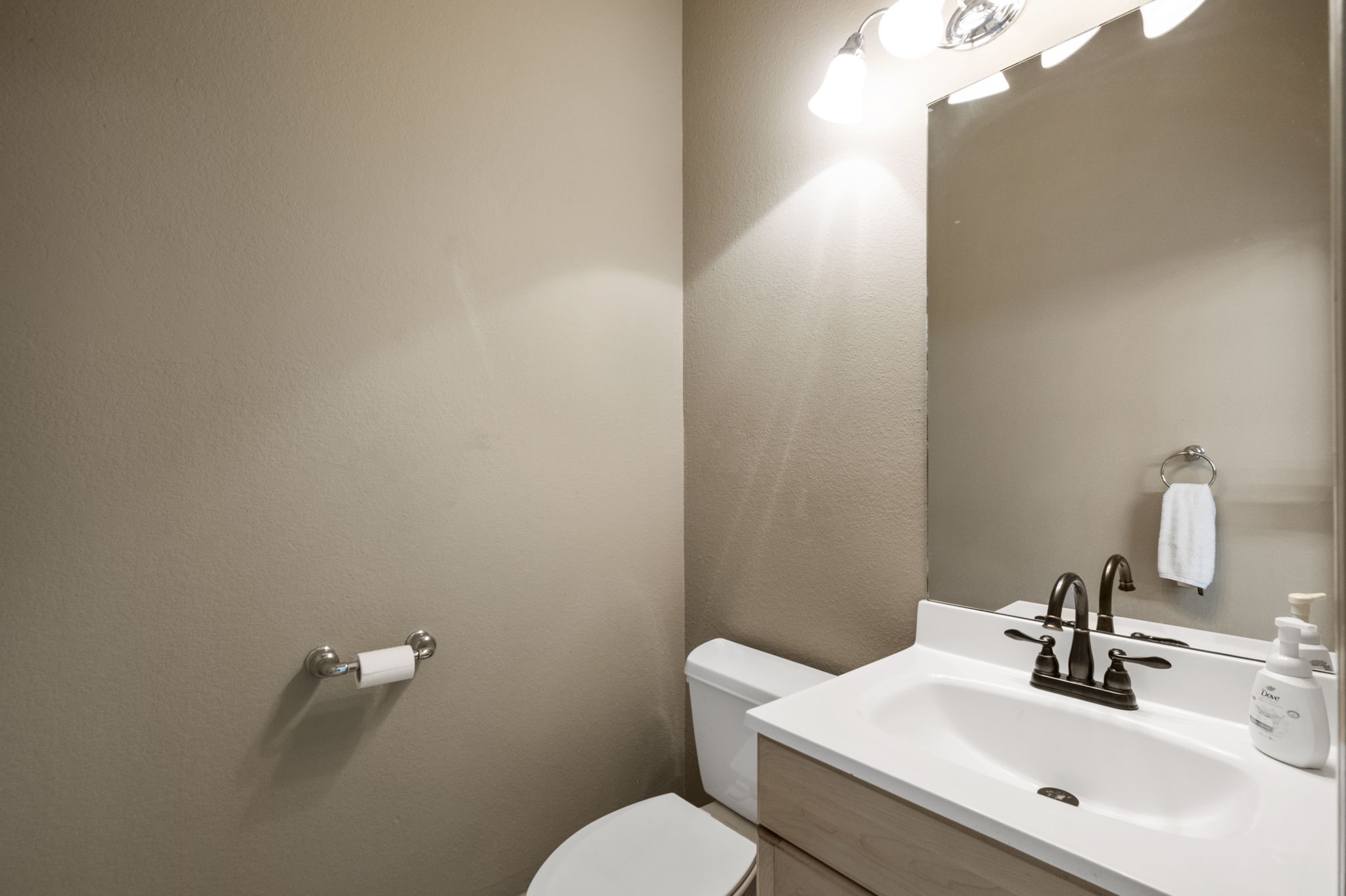 20010 Timber Ridge Drive Magnolia, TX 77355 - Photo 40 of 50 Conveniently located in the garage, this well-lit half-bath features a white vanity with a mirror, lighting, and modern fixtures. The neutral wall color adds a warm touch.