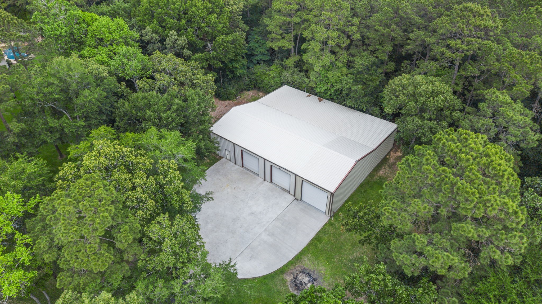20010 Timber Ridge Drive Magnolia, TX 77355 - Photo 42 of 50 This aerial view shows the private, detached, 5700 sqft workshop - the marvel of every craftsman and machinist! It has it's own second driveway/separate entrance, completely separate from the driveway leading to the main home. The building has stub outs for a bathroom, which also ties into the RV bay for a future RV clean out drain should one desire.