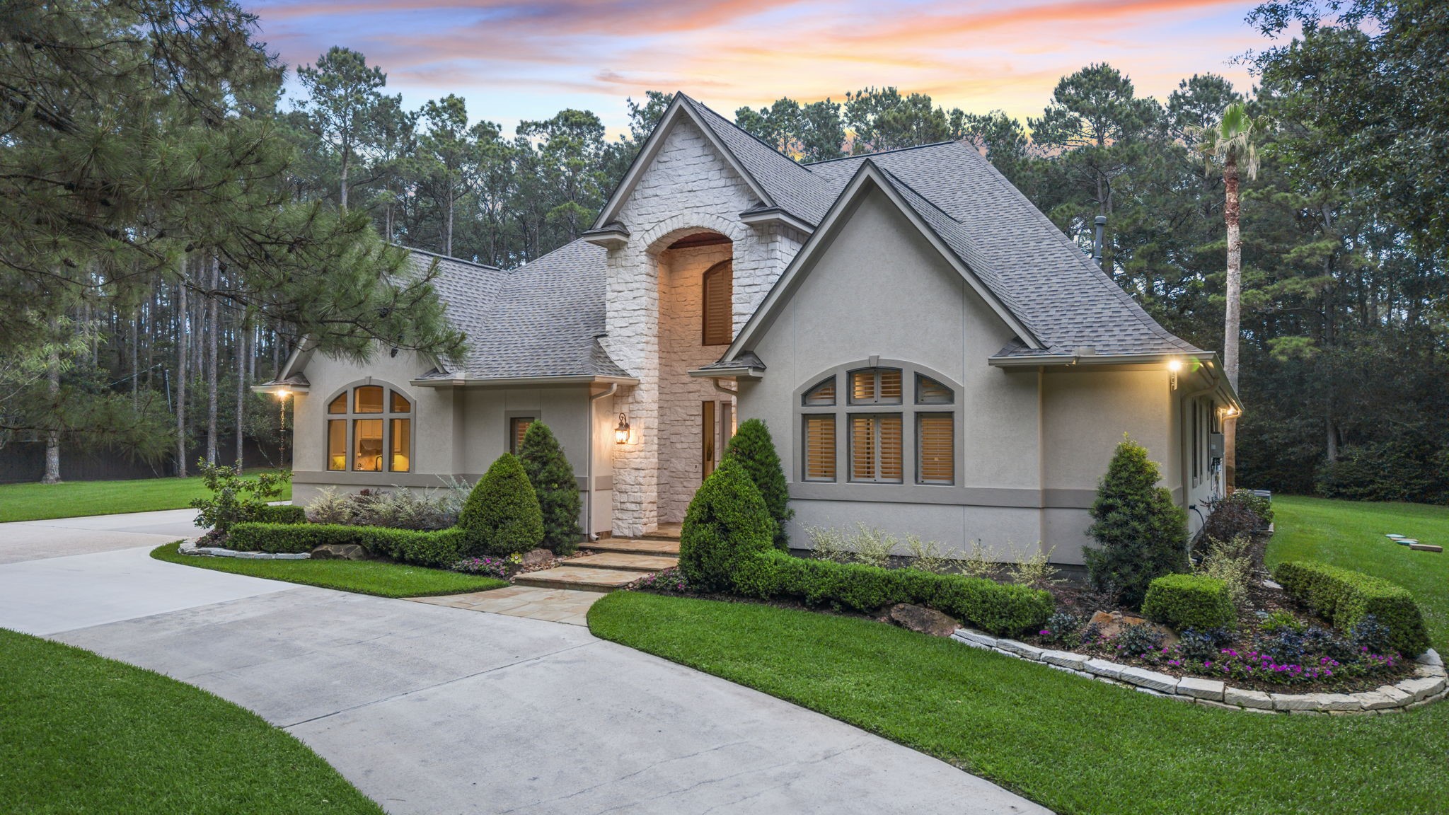 20010 Timber Ridge Drive Magnolia, TX 77355 - Photo 7 of 50 Arched windows add timeless character, while elegant columns grace the front porch, creating a stately entrance that blends sophistication with warmth. The beautifully maintained landscaping that creates a sense of peacefulness from the moment you arrive.