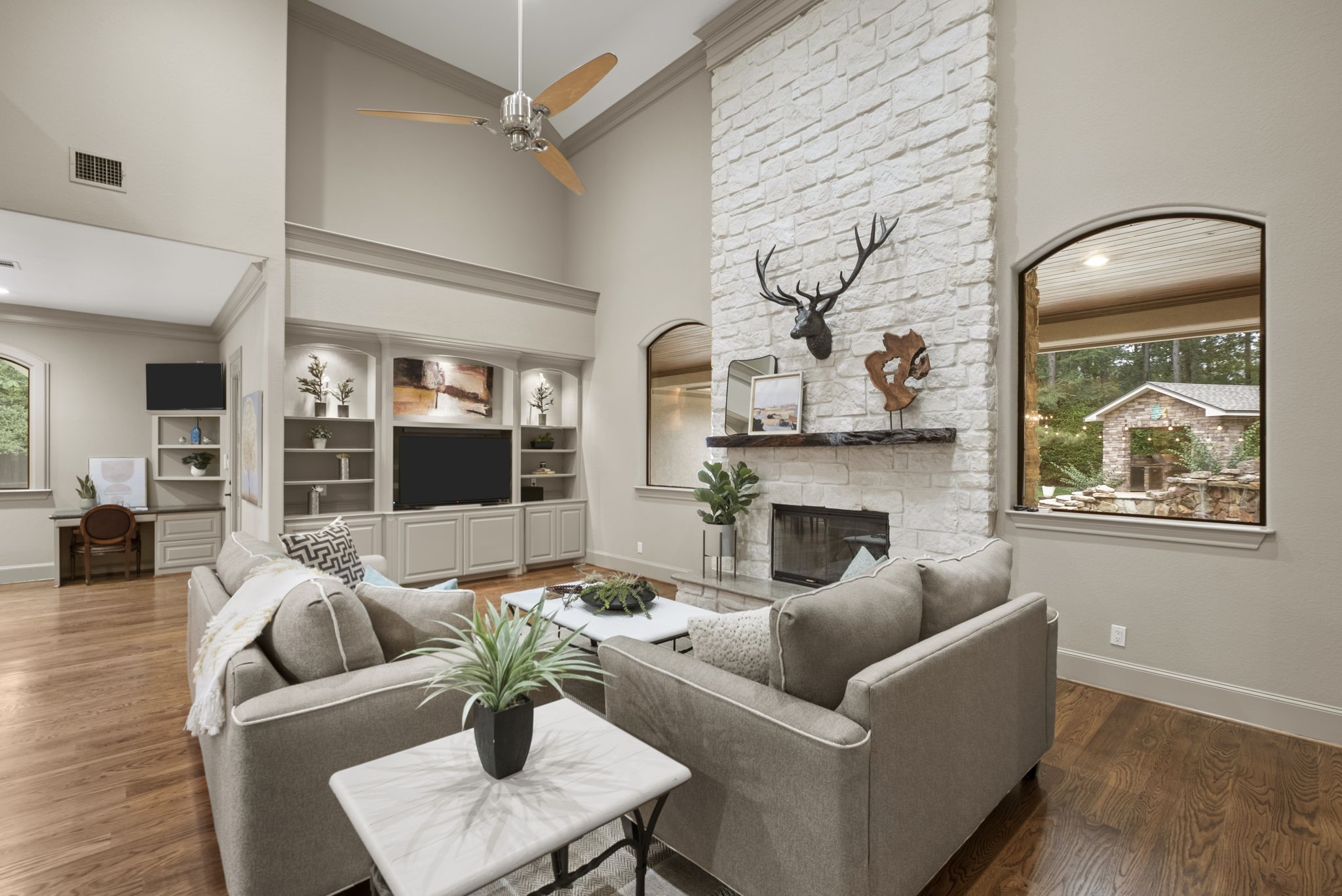 20010 Timber Ridge Drive Magnolia, TX 77355 - Photo 9 of 50 This inviting family room centers on a stunning floor-to-ceiling stone fireplace, creating a warm and timeless focal point. With its lofty ceilings, arched windows overlooking the pool, and welcoming ambiance, it’s a room that truly feels like the heart of the home.