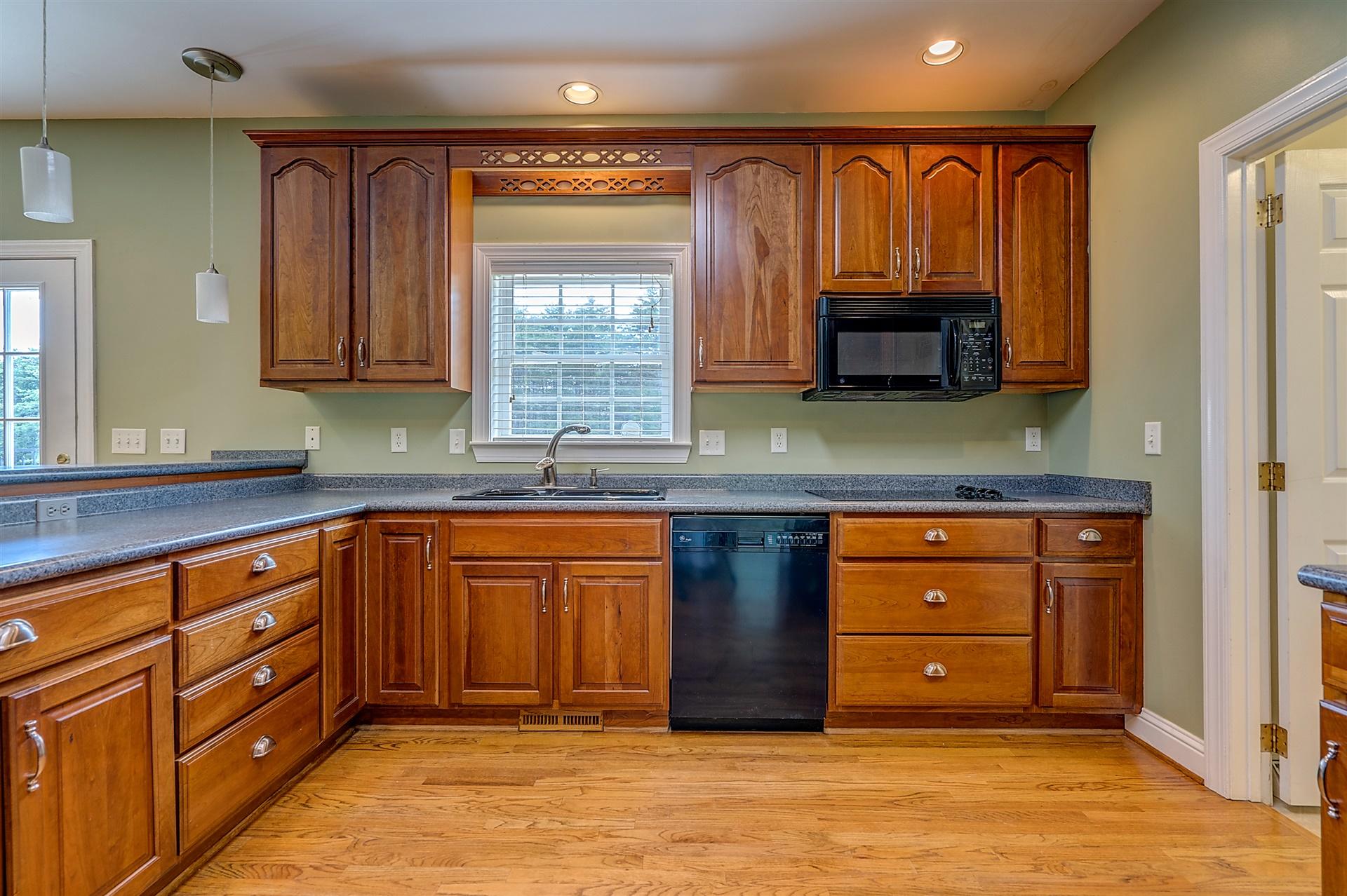 340 Mallard Point Road Wirtz, VA 24184 - Photo 15 of 41 a kitchen with granite countertop wooden cabinets a sink a window and stainless steel appliances