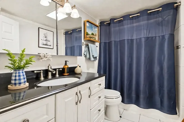 a bedroom with a bed and a potted plant next to a window