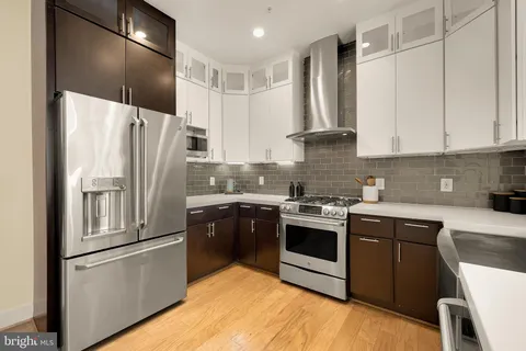 a kitchen with stainless steel appliances granite countertop a refrigerator a stove and a sink