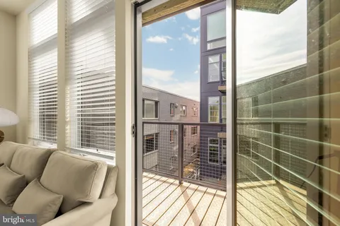a view of a balcony with floor to ceiling windows with wooden floor