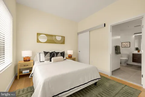 a bedroom with a bed a table and a large mirror