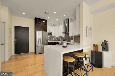 a kitchen with refrigerator and chairs