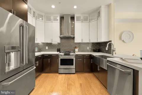 a kitchen with stainless steel appliances granite countertop a stove a sink and a refrigerator