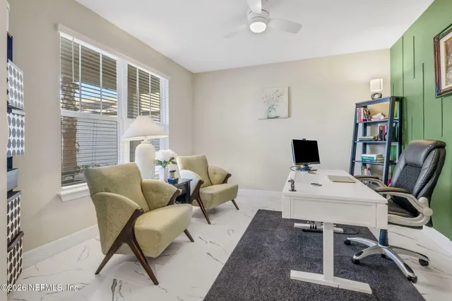 a living room with furniture and a view of kitchen