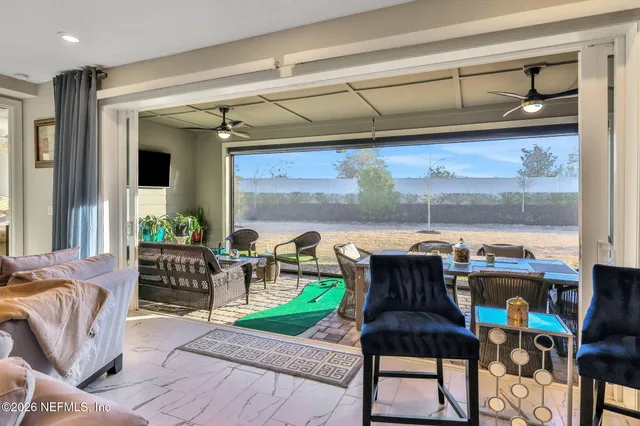 a view of a patio with couches table and chairs under an umbrella with a fire pit