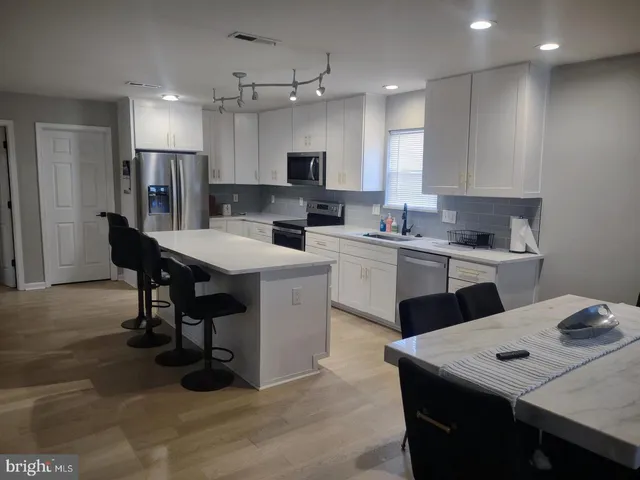 a kitchen with a sink a counter top space stainless steel appliances and cabinets