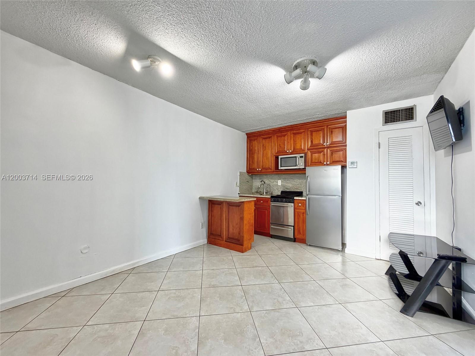 1340 Lincoln Road, Unit 709 Miami Beach, FL 33139 - Photo 2 of 13 a kitchen with stainless steel appliances granite countertop a sink and a refrigerator