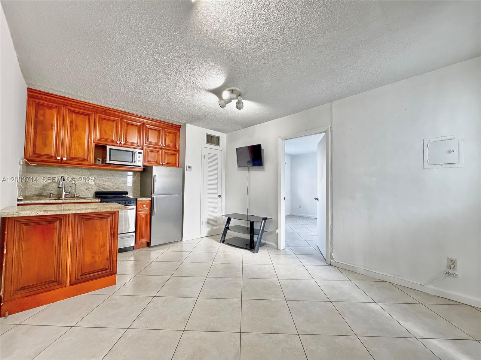 1340 Lincoln Road, Unit 709 Miami Beach, FL 33139 - Photo 3 of 13 a kitchen with stainless steel appliances granite countertop a refrigerator and a sink