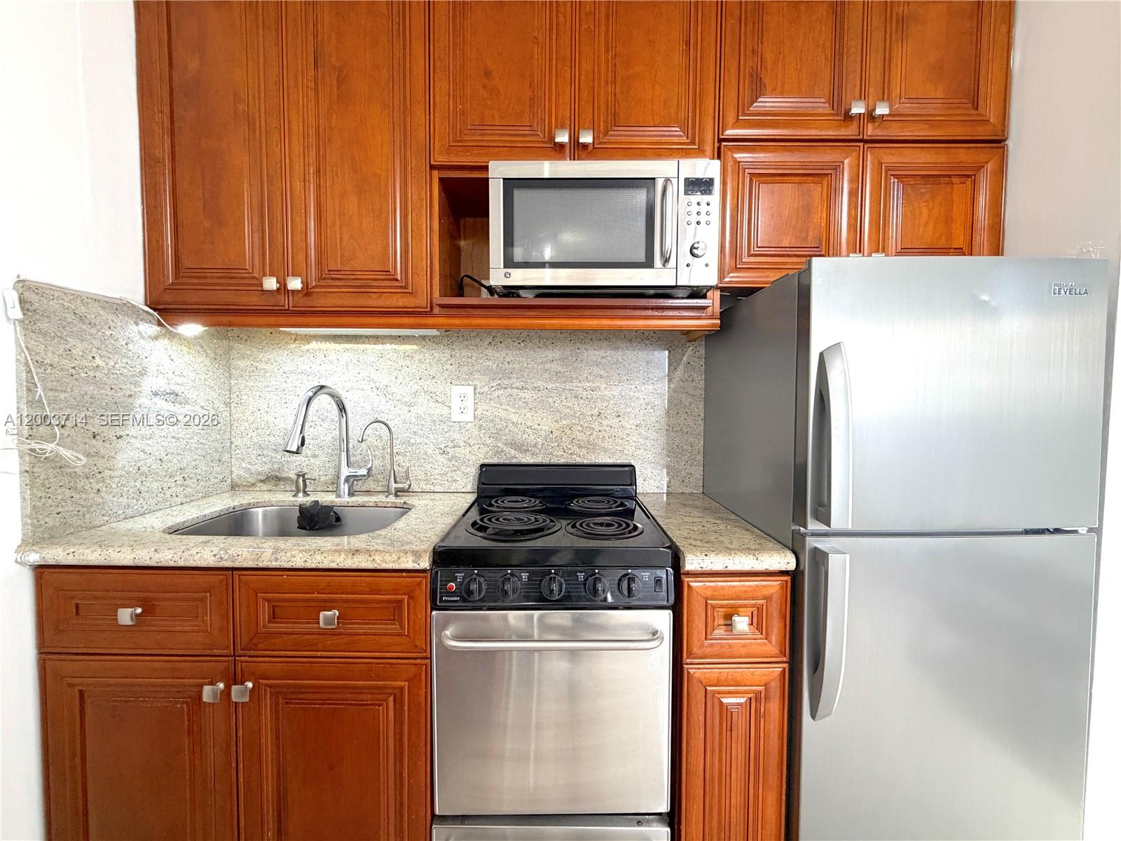 1340 Lincoln Road, Unit 709 Miami Beach, FL 33139 - Photo 4 of 13 a kitchen with stainless steel appliances granite countertop a refrigerator and a stove top oven