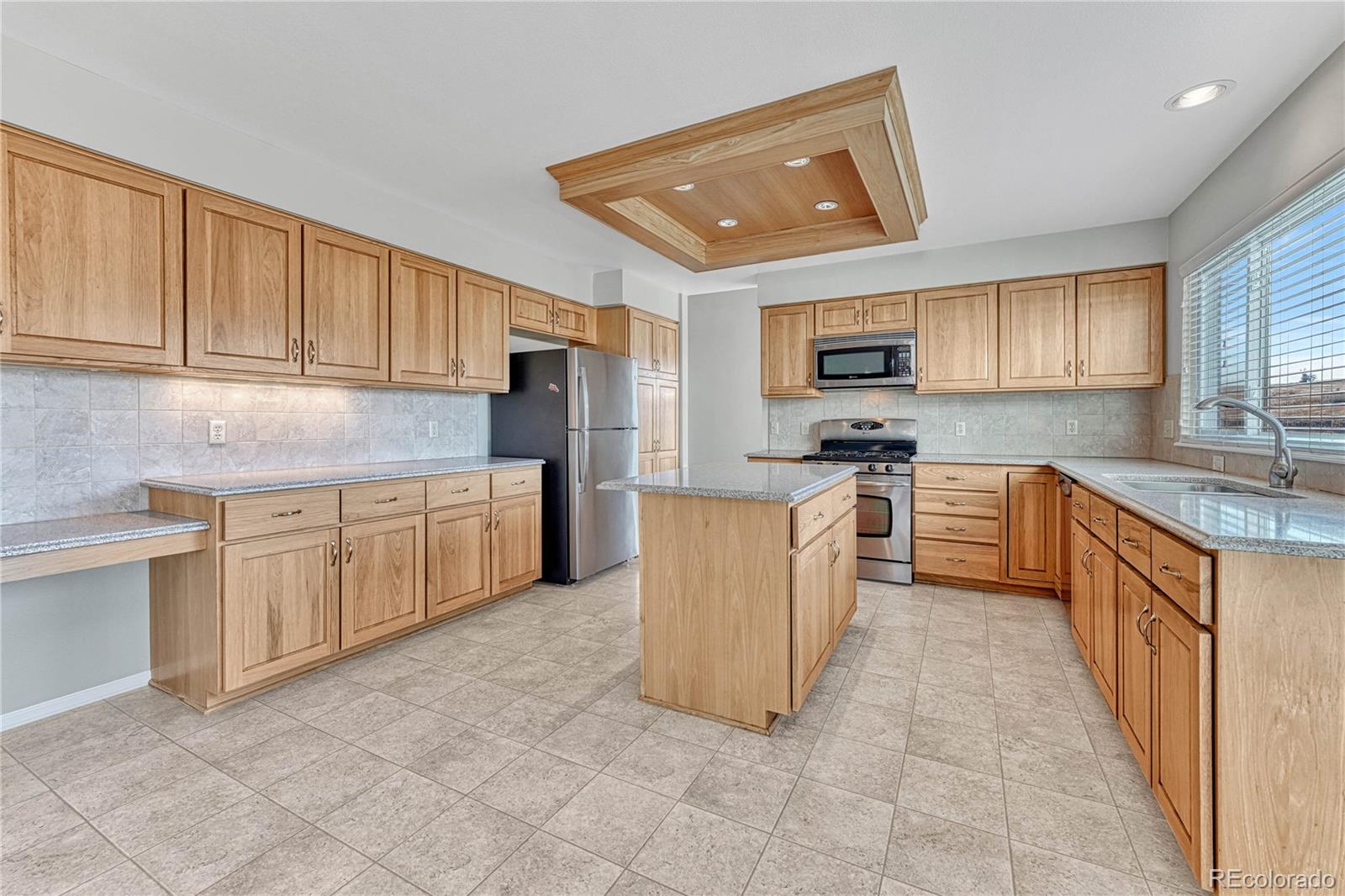 9858 Venneford Ranch Road Highlands Ranch, CO 80126 - Photo 14 of 50 a kitchen with cabinets a sink and a stove