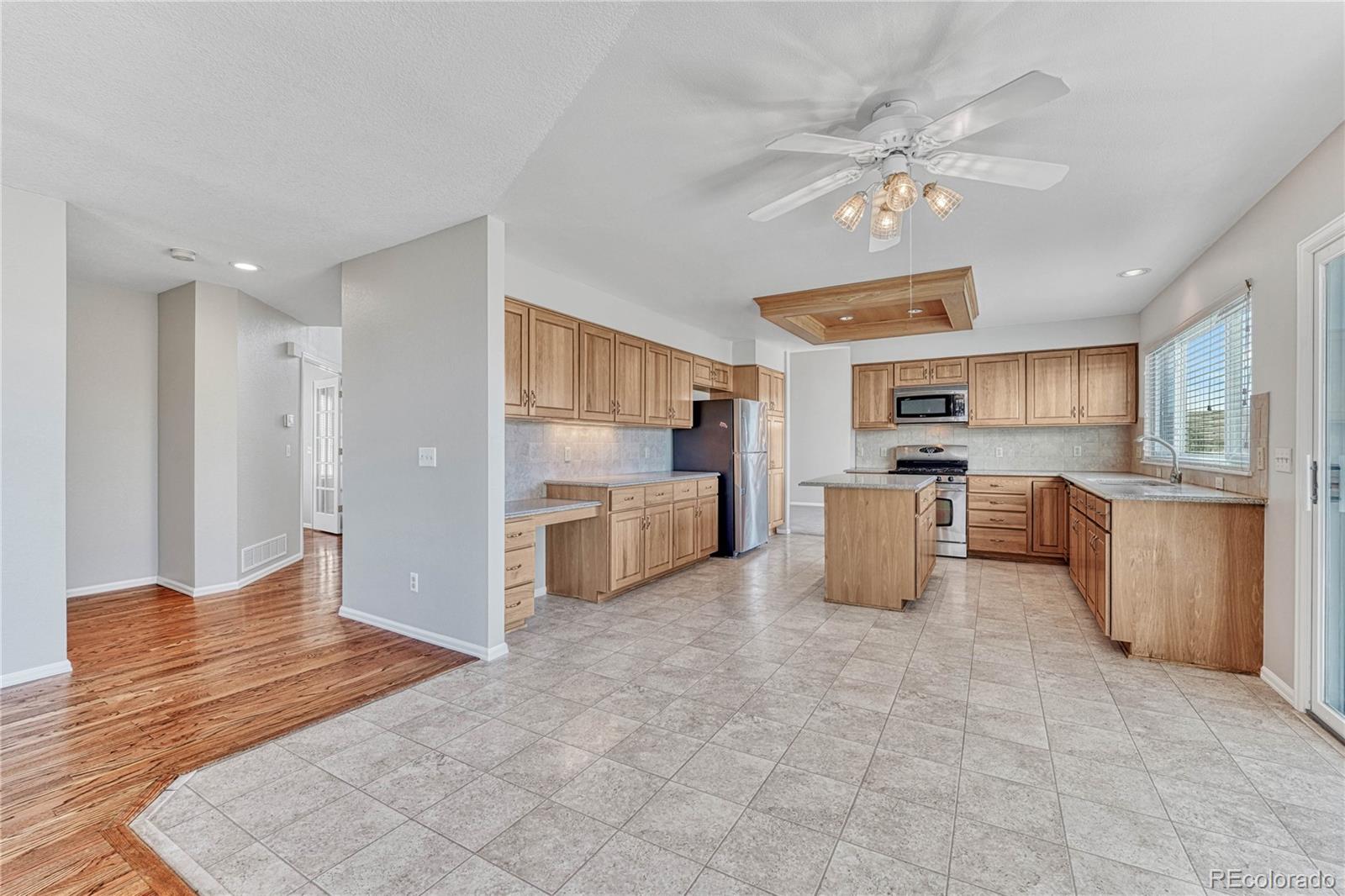 9858 Venneford Ranch Road Highlands Ranch, CO 80126 - Photo 15 of 50 a kitchen with granite countertop a refrigerator oven a sink a dining table and chairs