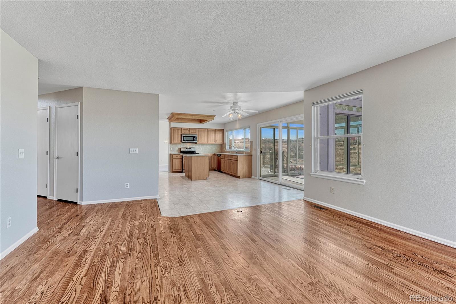 9858 Venneford Ranch Road Highlands Ranch, CO 80126 - Photo 19 of 50 a view of empty room with wooden floor and windows