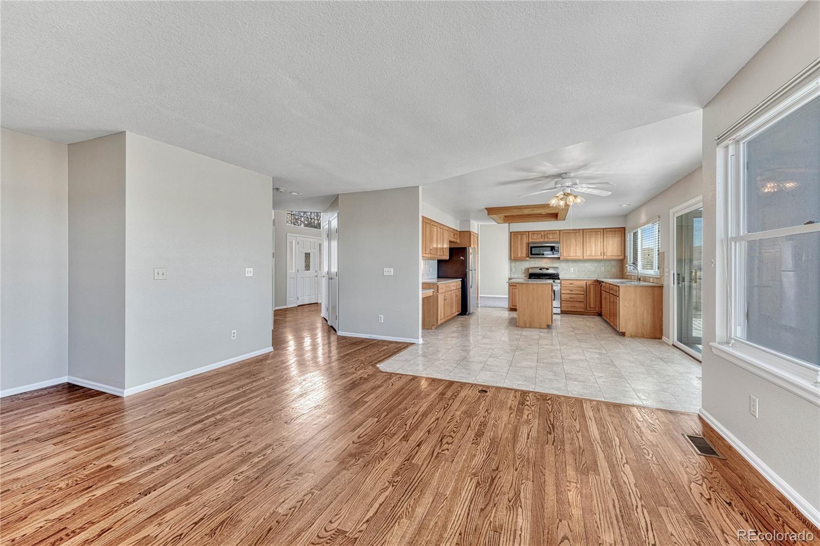 9858 Venneford Ranch Road Highlands Ranch, CO 80126 - Photo 20 of 50 a view of a living room and kitchen with wooden floor
