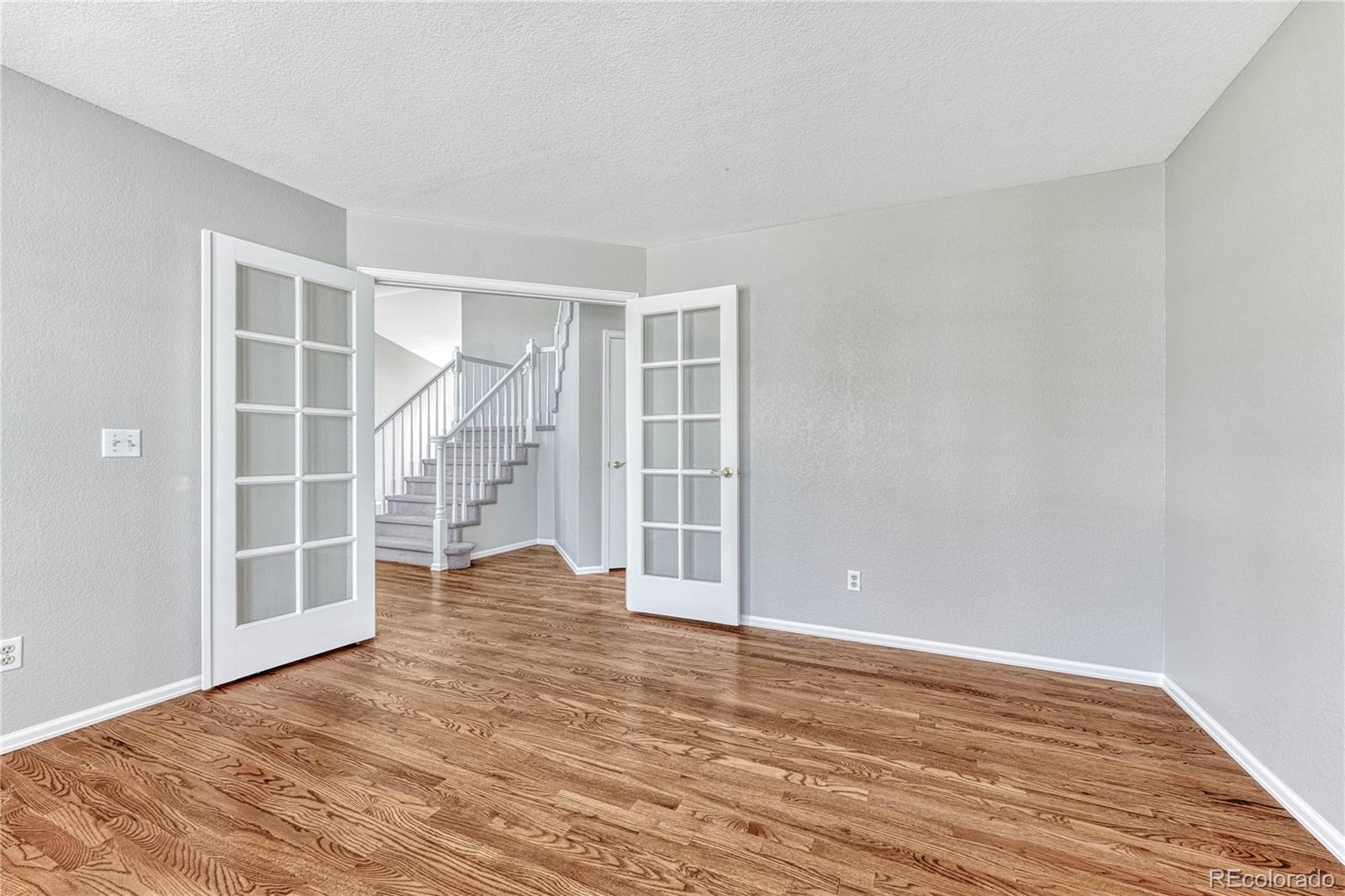 9858 Venneford Ranch Road Highlands Ranch, CO 80126 - Photo 25 of 50 a view of empty room with wooden floor and windows