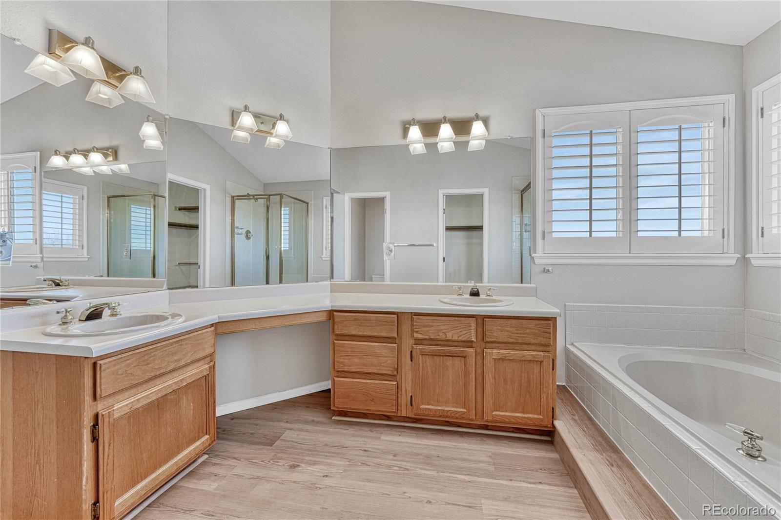 9858 Venneford Ranch Road Highlands Ranch, CO 80126 - Photo 34 of 50 a large bathroom with a large tub double vanity sink and a large mirror