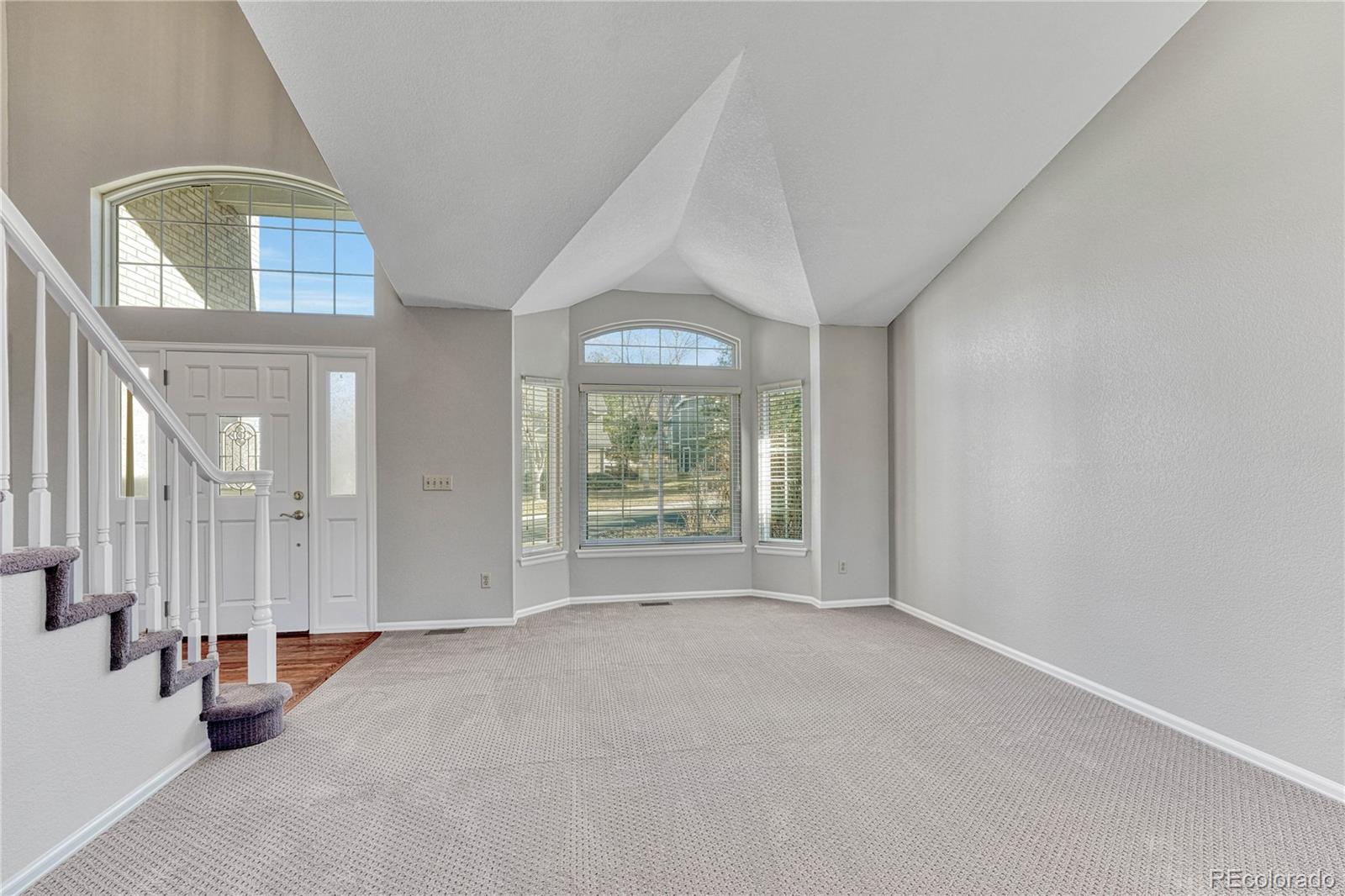 9858 Venneford Ranch Road Highlands Ranch, CO 80126 - Photo 5 of 50 an empty room with windows and mirror