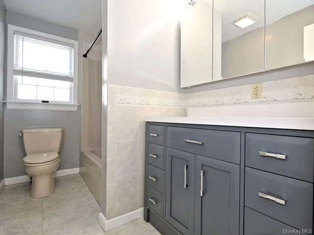 a view of an empty room with wooden floor and window