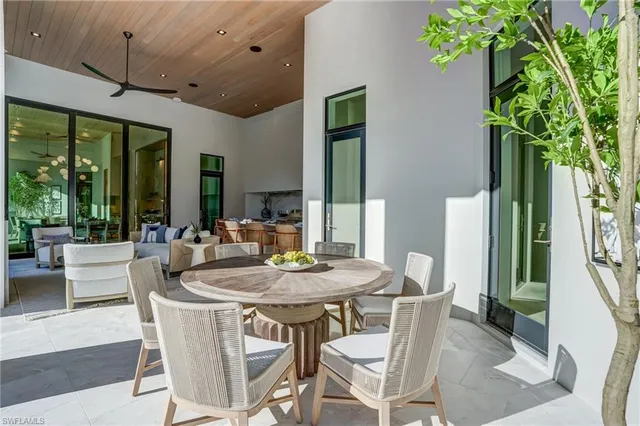 a dining room with furniture potted plants and wooden floor