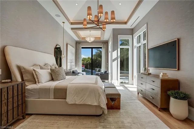 a spacious bedroom with a bed and a flat screen tv