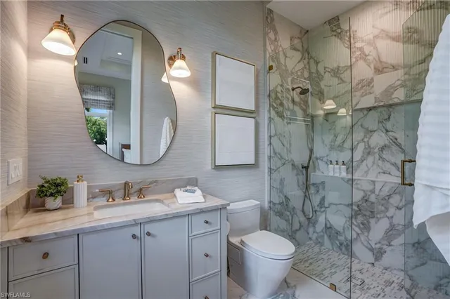 a bathroom with a granite countertop toilet a sink and a mirror