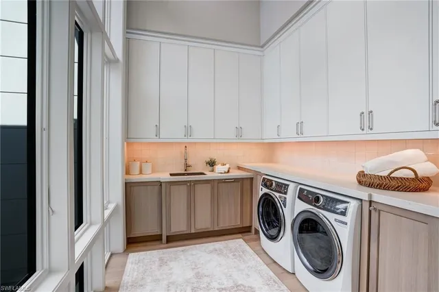 a utility room with sink dryer and washer