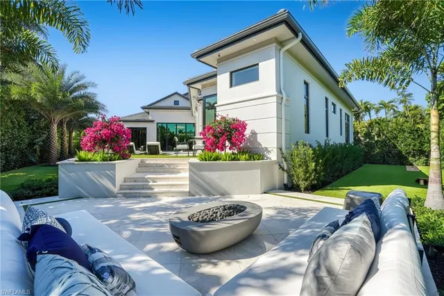a view of a white house with a potted plant and a fountain