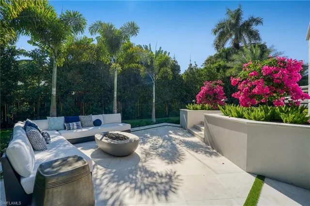a view of a patio with couches table and chairs and potted plants