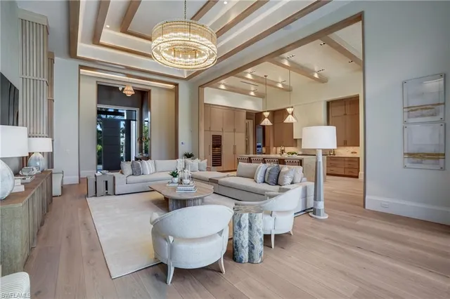 a living room with couches and kitchen view with wooden floor