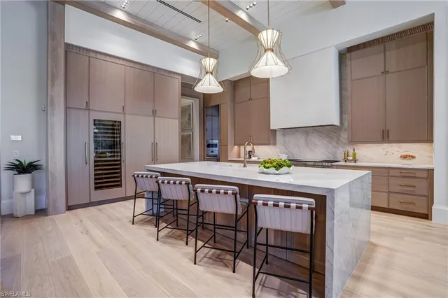 a kitchen with a table chairs cabinets and wooden floor