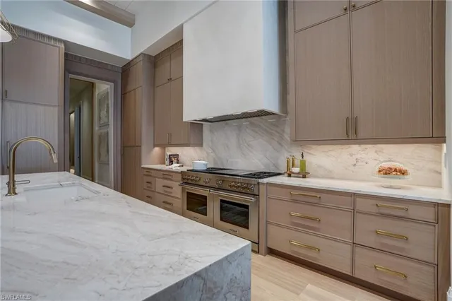 a kitchen with stainless steel appliances granite countertop a stove a sink and a refrigerator