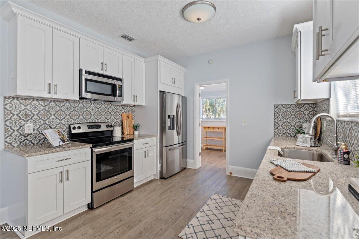 933 Talbot Avenue Jacksonville, FL 32205 - Photo 12 of 41 a kitchen with granite countertop a sink stove and refrigerator