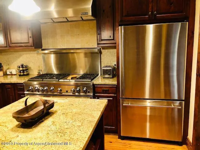 a kitchen with a refrigerator and a stove