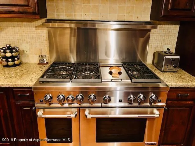 a stove top oven sitting inside of a kitchen