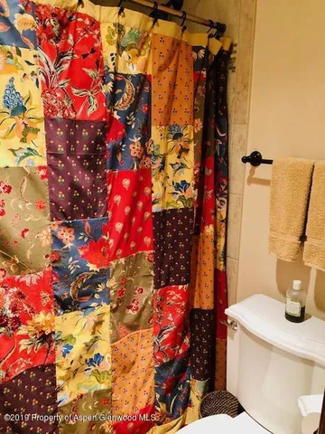 a bathroom with a granite countertop sink toilet and mirror