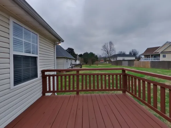 a view of a wooden deck with large trees