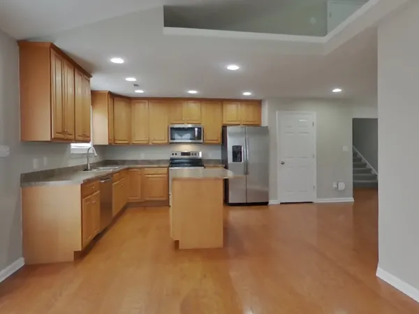 a large kitchen with stainless steel appliances granite countertop a stove a sink a refrigerator and a cabinets
